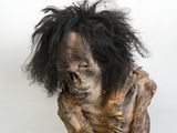 un gros plan sur la statue d'une personne aux cheveux noirs