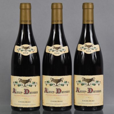 trois bouteilles de vin posées sur une table l'une à côté de l'autre