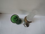 a green vase and a glass on a white table
