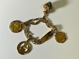 une image représentant un bracelet en or orné de pièces de monnaie et d'une croix