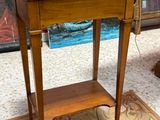 a small wooden table with a drawer on top of it