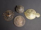 three antique brass buttons and a coin on a black surface
