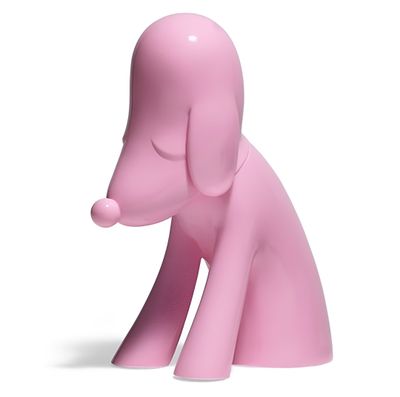 une figurine de chien rose posée sur une surface blanche