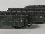 four toy trains that are lined up on a white surface