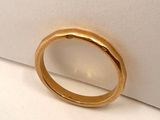 a close up of a gold ring sitting on top of a white surface