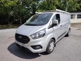 une camionnette blanche garée sur un parking avec des arbres en arrière-plan
