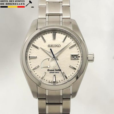 a close up of a watch with a white dial