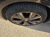 tire of a car on the ground with a person standing next to it