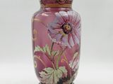 un vase rose orné d'un motif floral