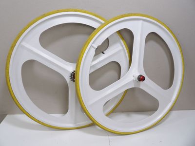 two white wheels with yellow rims sitting on a white surface