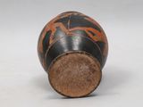 an image of a black and orange vase on a white surface