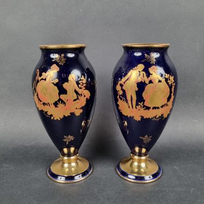 pair of blue and gold vases with figures on them on a gray background