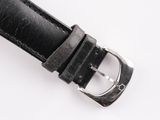 black leather watch strap with silver buckle on white surface
