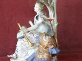 une figurine représentant une femme assise sur un arbre avec un enfant