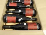 six bottles of red wine in a cardboard box on a table