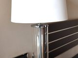a lamp that is sitting on a table next to a bed