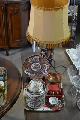 a table with a lamp, plates, and cups on it