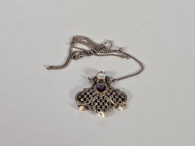 gros plan d'un collier sur une surface blanche avec une chaîne