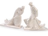 two figurines of a man and a woman sitting on a bench