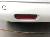 a white car that has a red tail light on it