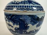 un bol bleu et blanc avec un couvercle, posé sur une table blanche