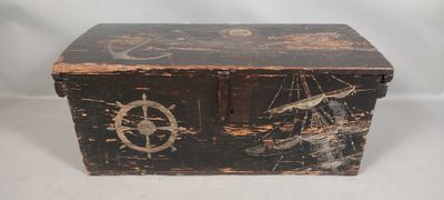 une vieille boîte en bois ornée d'un motif représentant un bateau et une boussole