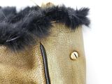 a close up of a gold purse with black fur