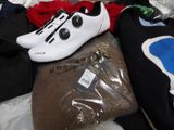 a pile of clothing and a pair of shoes on a bed