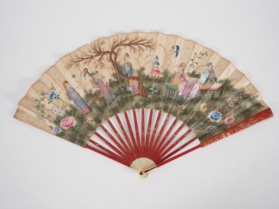 an old fan with a painting on it sitting on top of a table