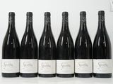 six bouteilles de vin sont alignées sur une table