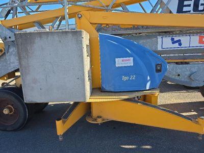 une grue jaune et bleue avec un godet bleu à l'arrière
