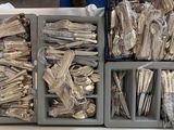 several trays of silverware sitting on top of a table