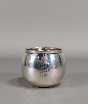 une image représentant une coupe en argent munie d'une anse, posée sur une table