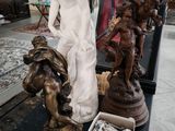 une statue représentant une femme assise sur une table, à côté d'autres statues