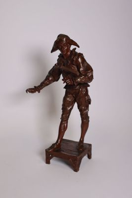 une statue représentant un homme coiffé d'un chapeau, posée sur un socle
