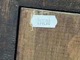a close up of a picture of a wooden frame with a label on it