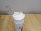 a plastic cup with a plastic handle on a wooden table