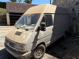an old van is parked in front of a brick building