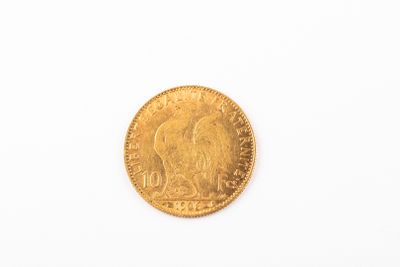 gros plan d'une pièce d'or sur une surface blanche