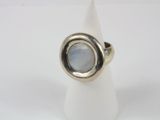 un gros plan d'une bague sertie d'une pierre, posée sur un cône blanc