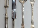 four forks, a knife, and a spoon on a table