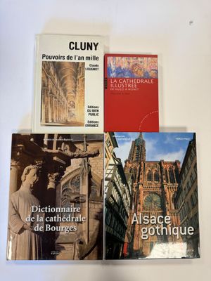 trois livres posés sur une table, avec une horloge et un clocher en arrière-plan