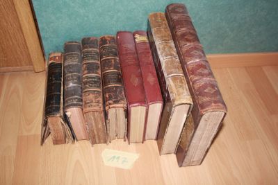 several old books are lined up on the floor in a row