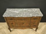 a marble top chest of drawers on a chevroned wood floor