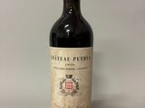 an old bottle of wine sitting on top of a white table