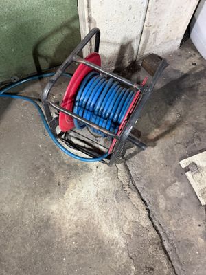 un tuyau fixé à un dévidoir posé au sol