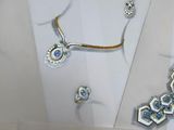 several pieces of jewelry are displayed on a table in a display case