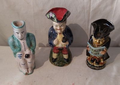 trois figurines assises l'une à côté de l'autre