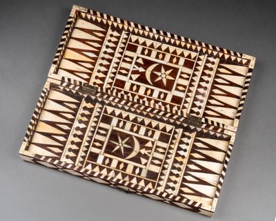 une vieille boîte en bois décorée, posée sur une table