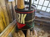 un seau muni d'une pompe à eau, à côté de deux tonneaux en bois